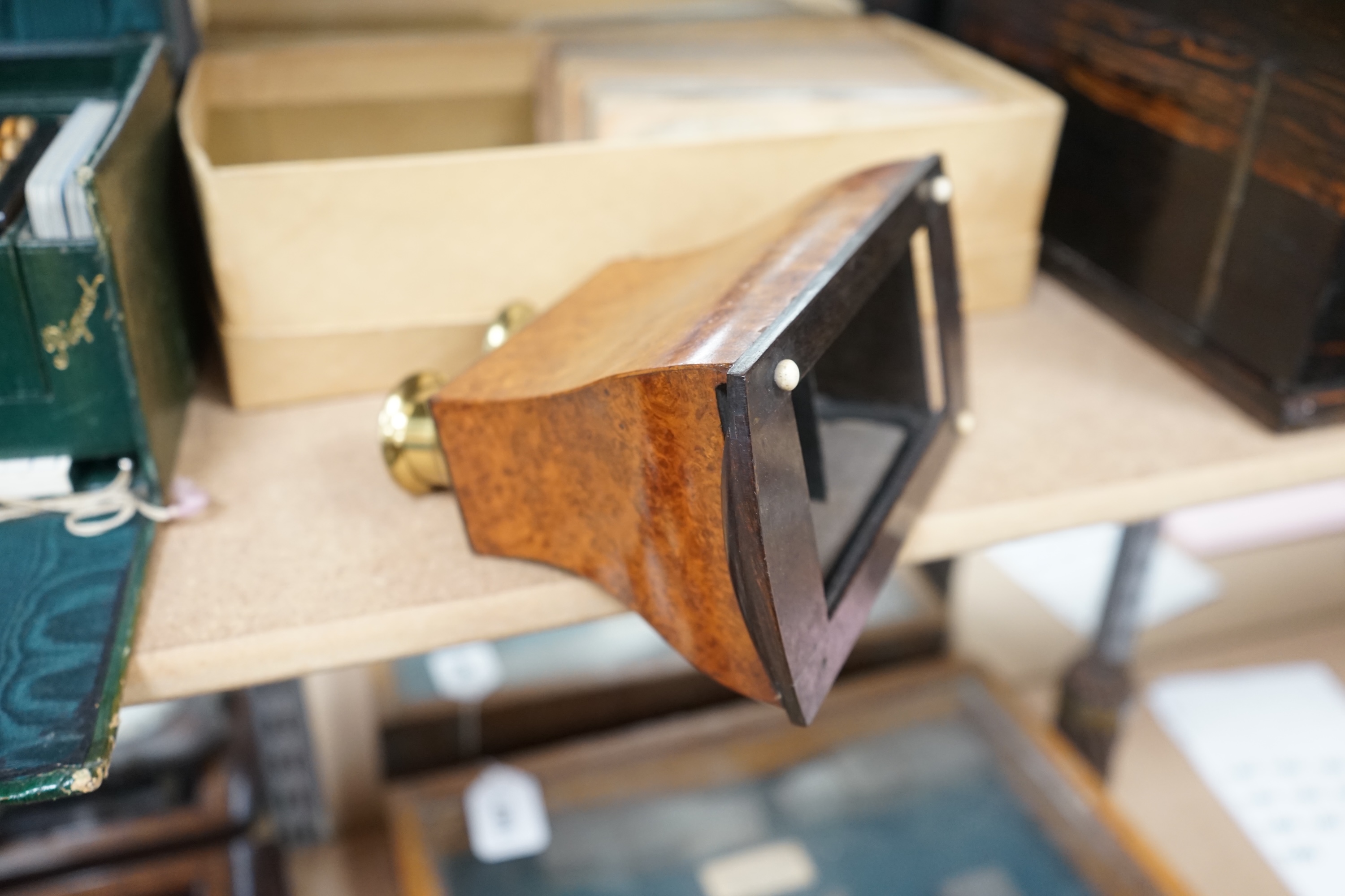 A Cook's patent stereoscope viewer and viewing cards together with a green Morocco leather playing cards box, box 12.5cm high x 24cm wide. Condition, games box poor, viewer and cards good